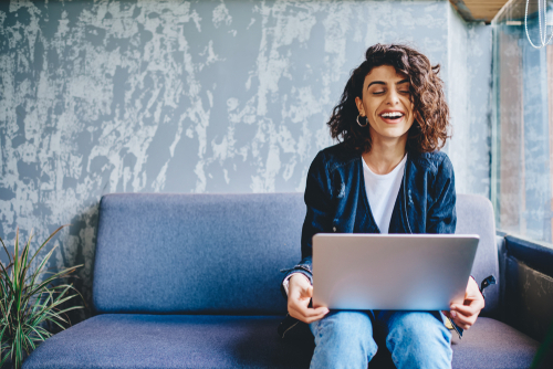 Woman sitting laughing at her computer