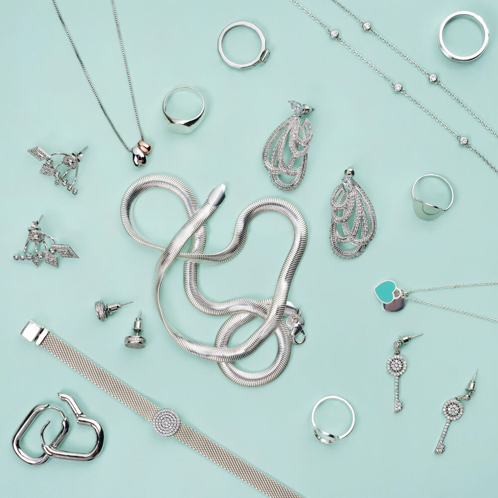 Silver jewelry placed on a mint background